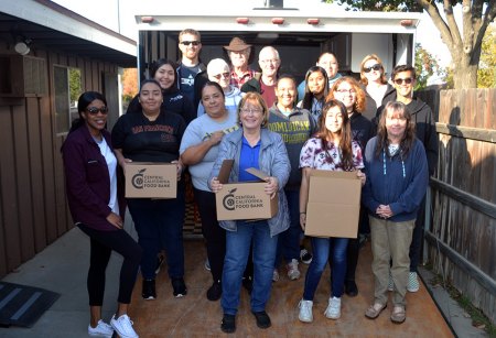 Holiday season is well under way as Lemoore Christian Aid volunteers pack gift boxes for upcoming Christmas events Lemoore Christian Aid volunteers take a break for a group photo before they get back to packing boxes with food for the holiday season.